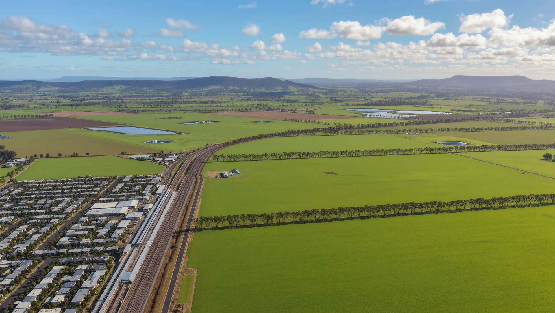 Aerial artist's impression of the Wallan East precinct with the township, rail corridor and rolling farmland.